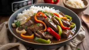 Make the best Slow Cooker Pepper Steak at home with this easy recipe! Tender beef, crisp peppers, and savory gravy make this dish a family favorite. Perfect over rice or noodles!